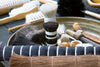 Brushes with natural bristles made with horsehair, goat hair, and plant fibers arranged in a workshop tray