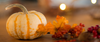 Small striped pumpkin close-up: “Miniature striped pumpkin with autumn leaves and warm bokeh lights.”